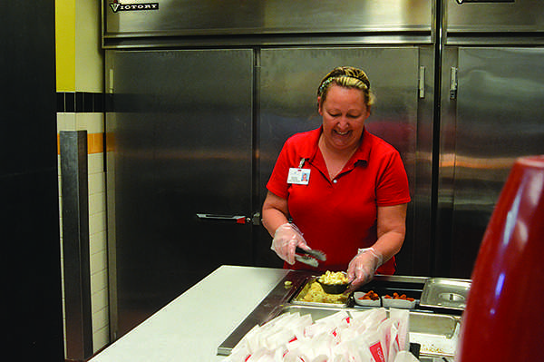 Student Nutrition Services Manager Debbie Ferguson prepares the daily offerings in the cafeteria. Ferguson assumed her new position this  April.