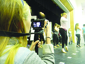 A budding documentarian, senior Maddy McKay will capture the behind-the-scenes creation of “Cabaret,” the school’s spring musical.
 McKay’s movie marks the first time that a student has created a documentary of this caliber on a school production.
As an aspiring filmmaker, McKay hopes that undertaking this project will allow her to expand her skill set for the future.
“This is what I want to do as a profession. Nothing like this has ever been done and that’s why I want to do it,” McKay said. “ I wanted to create something real.”
“I want to show the whole process of a show, not just the final product,” McKay said. 
Senior cast members displayed a particular sentimentality regarding their final school production.
 “At some point in my life I will want to look back at my high school theatre experience. ” Nick Russo, senior, said. “Who knows what she’ll capture on tape!”
Although senior members of the cast appreciated McKay’s documentation of their last play, underclassmen cast members  on “Cabaret” shared a similar sense of excitement.
“I think this will be a really fun experience,” Elizabeth Doney, sophomore, said. “I think it will be interesting to watch it all come together after we’ve finished.”
Involvement in McKay’s documentary left some cast members with a newfound appreciation of the process of integrating all of the elements of a show. 
“Documenting all of the steps we have to take to achieve our goal of a great show has given me a different outlook on the creation of ‘Cabaret’,” Marissa Sandler, junior, said.
While some of the cast and crew of “Cabaret” might have regarded the documentary with skepticism initially, a consensus seemed to exist that the additional project did not interfere with rehearsals.
“We get so focused on what we’re working on that you almost forget she’s filming,” Doney said.
McKay’s documentary will conclude when the show opens to student viewers in April.