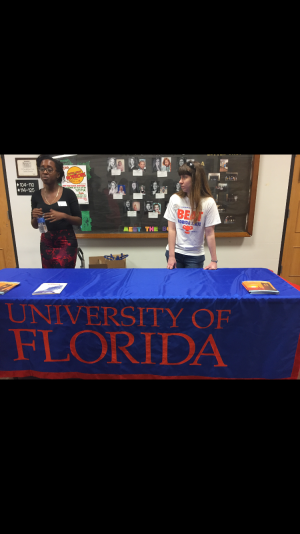 A University of Florida's admission officer and alumni await students at the front of the auditorium before they enter the UF seminar in the auditorium.