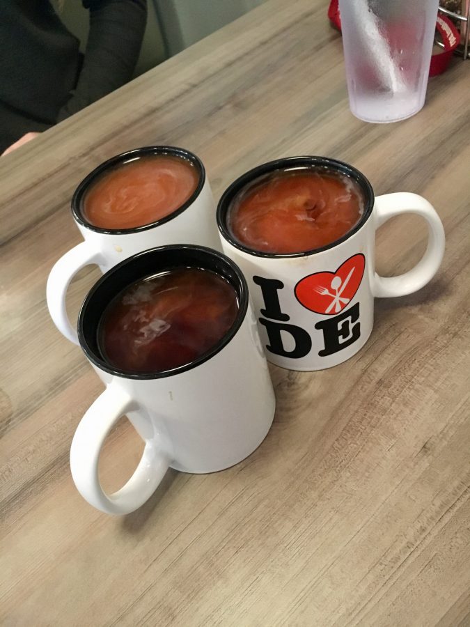 Coffee at Daily Eats is served in mugs. Customers chose flavors from the options of Vanilla, Caramel, and Hazelnut.
