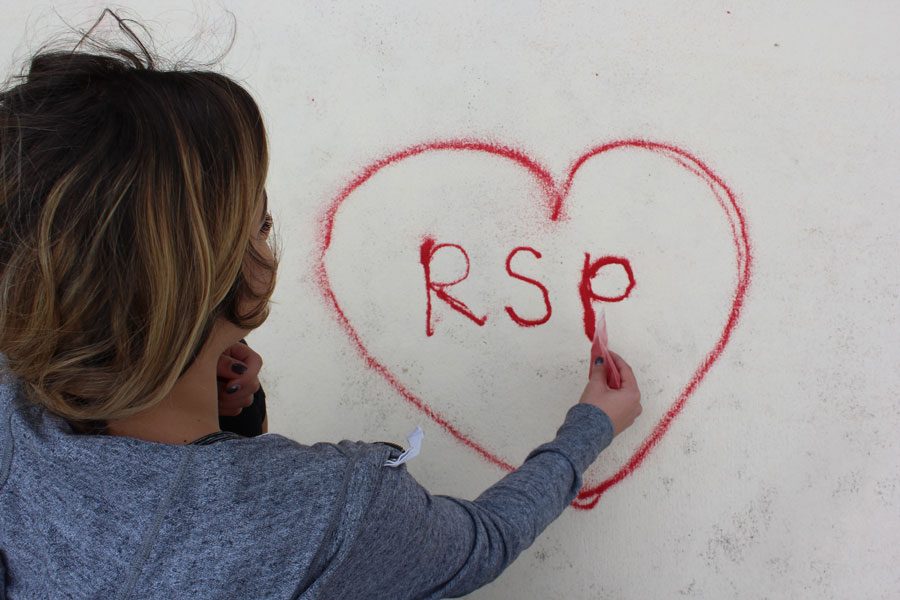Using more than just one bag of sand, senior Bella Guggino shows her support for the Red Sand Project by making a heart with RSP in it.