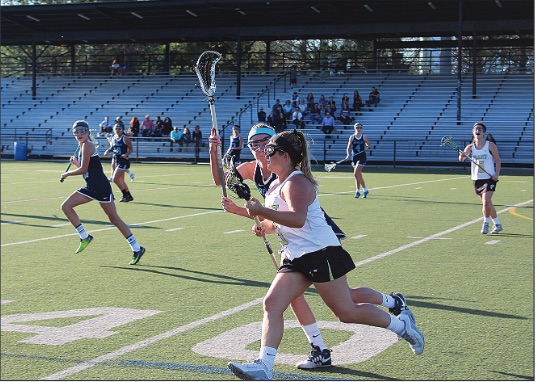 During a game against Berkeley Prep on March 3, senior Delaney Turton runs up field while being guarded by a Berkeley defender. The team went on to win the game by a score of 11 to 6. 