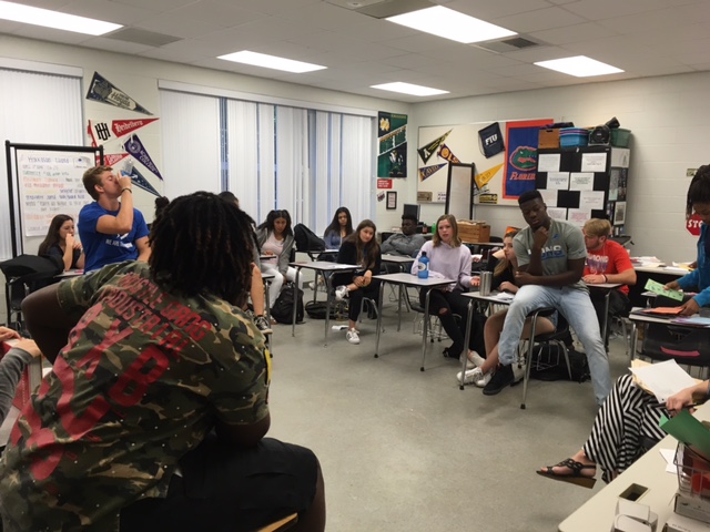 Gathering in the AVID classroom, students participate in philosophical chairs.