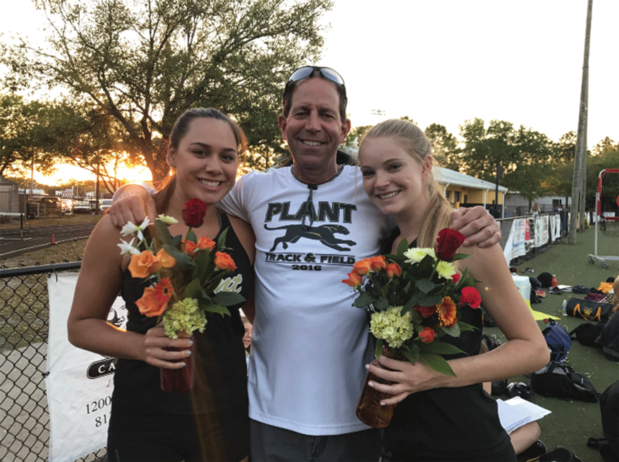 Captains Zoe Gholson and Skyler Blevins, both seniors, pose with coach Roy Harrison on senior night.