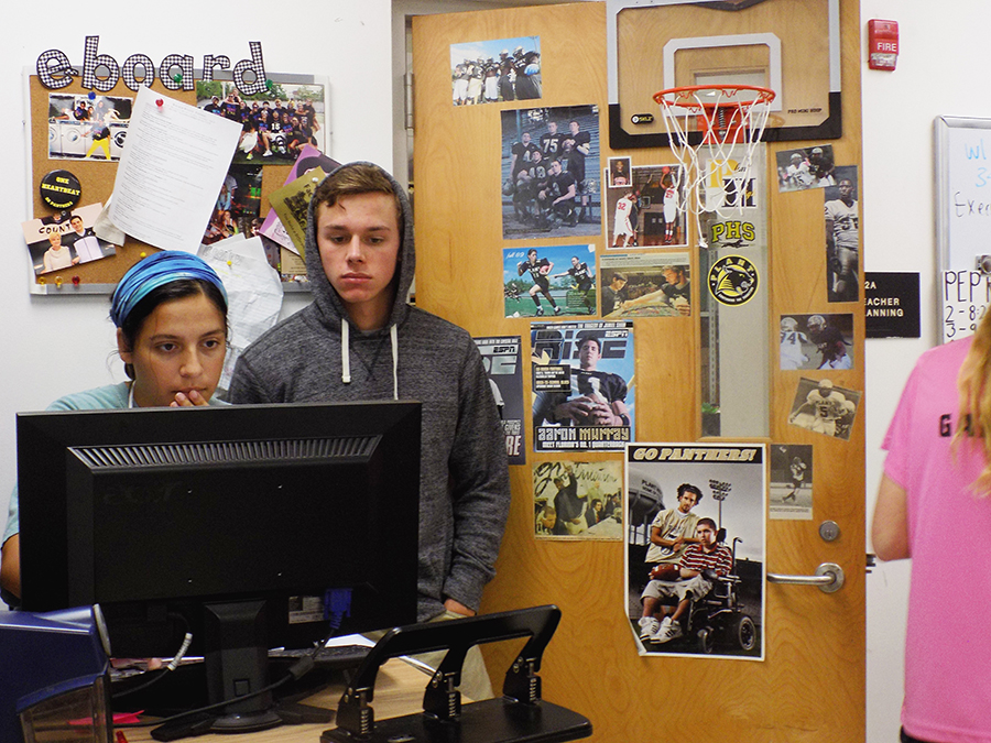 E-board members, Lena Diasti and Hunter Owens, junior and senior, search on the computer for Homecoming accommodations such as a DJ.