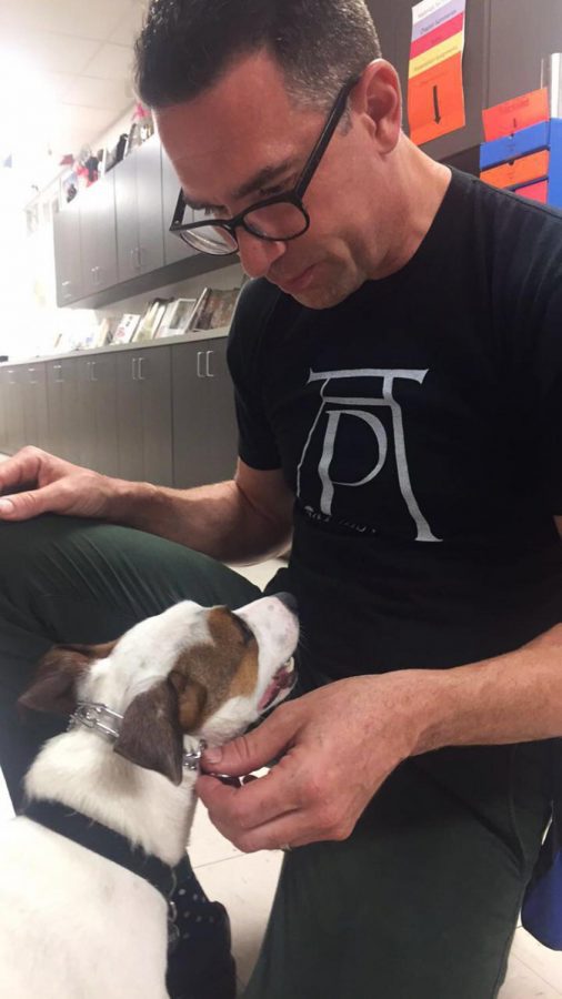 Rewarding his dog Angus, AP Art History teacher Bill Renninger pets his dog after training in Rnninger's classroom.