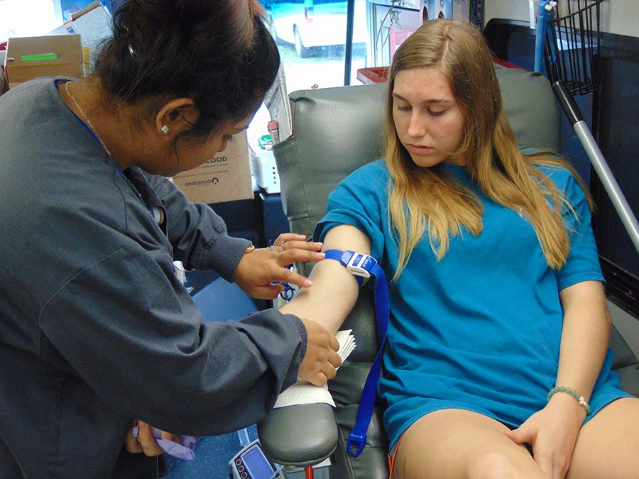 Looking down as the nurse disinfects her arm, senior Anna Smith prepares to give blood.