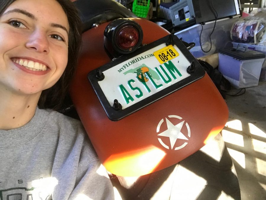 Senior Stephannie Benner poses next to one of her favorite license plates.