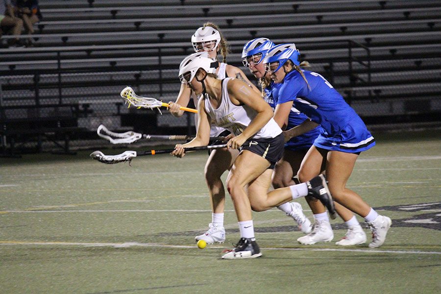 Joined by her opponents and a fellow team player, junior Lexi Ashby tries to gain possession of the ball.