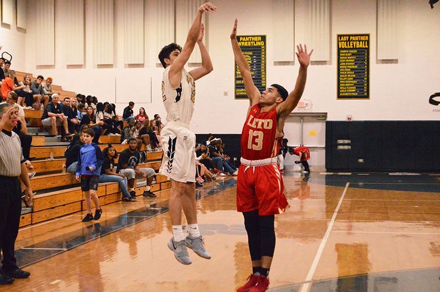 Logan Morrissey goes for the three while Leto player Luis Maldonado tries to block at a home game against Leto Highschool on Jan. 12.