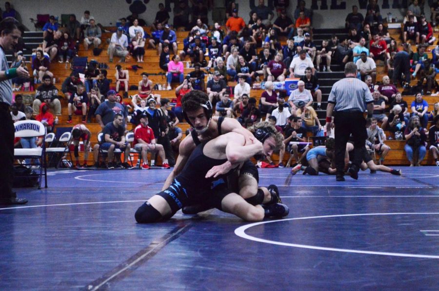 During the County Championships at Wharton High School, Carter Ellis reaches to pin down competing Steinbrenner High School wrestler on Feb. 9.