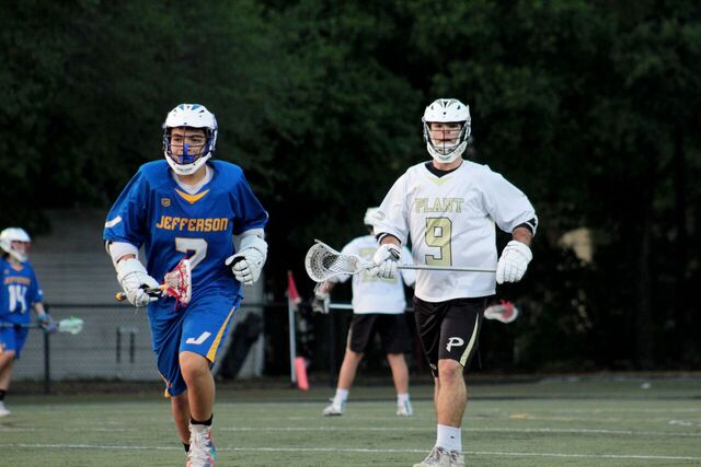 Alex Alonso runs off the field with Jefferson player, so the next players can sub in at a home lacrosse game against Jefferson high school on Mar. 20.