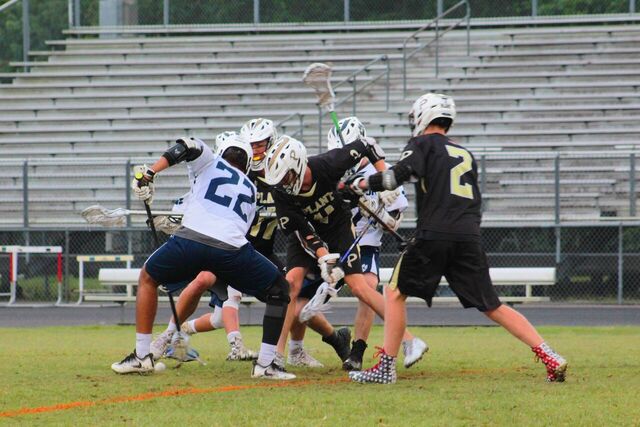 Players battle it out to get the ball at the lacrosse game at Wharton High School on Apr. 10.