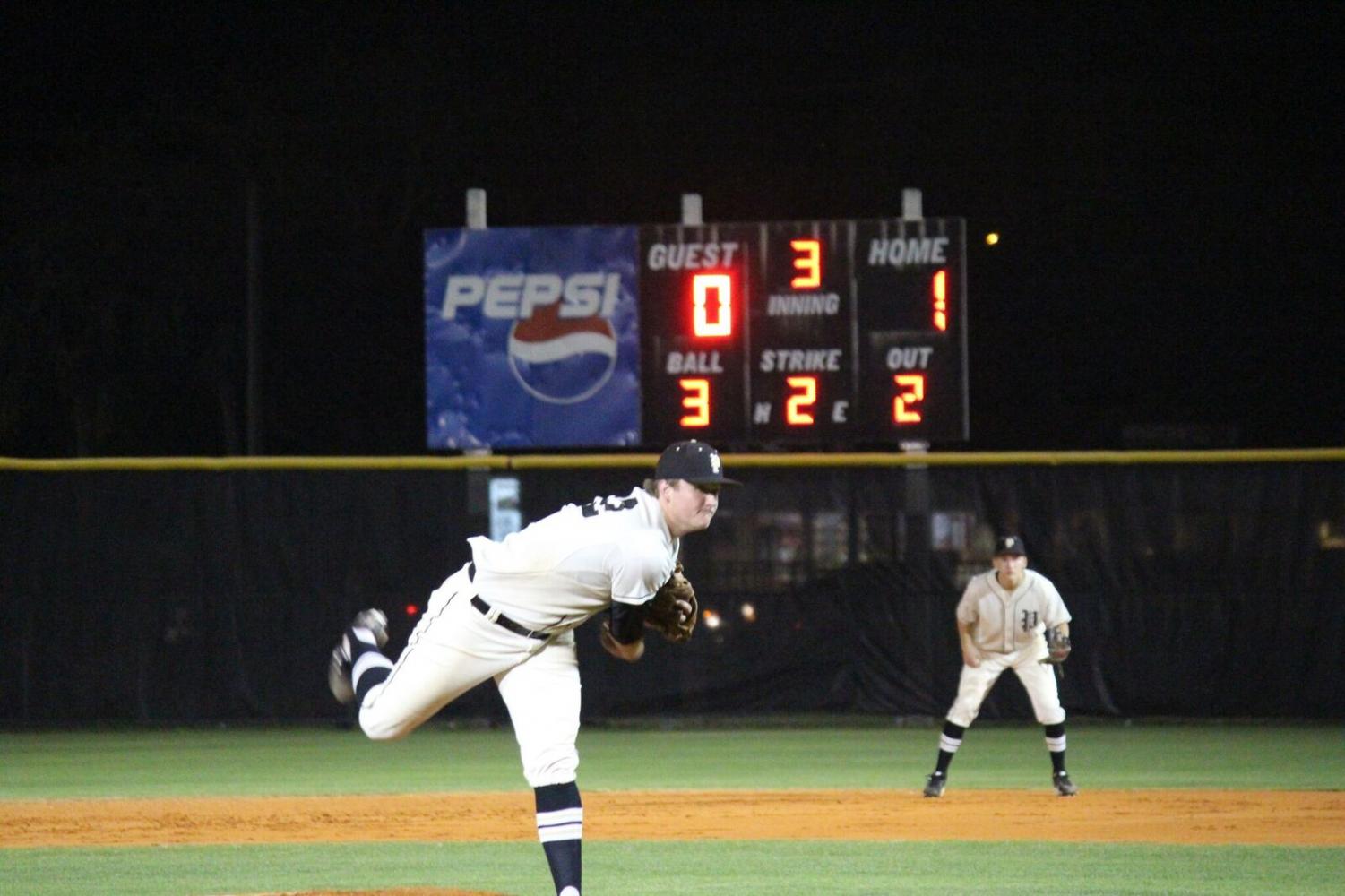 Throwing a fast ball, senior Brock Fagler executes the wind up for a fast pitch to secure a home win of 8-0.
