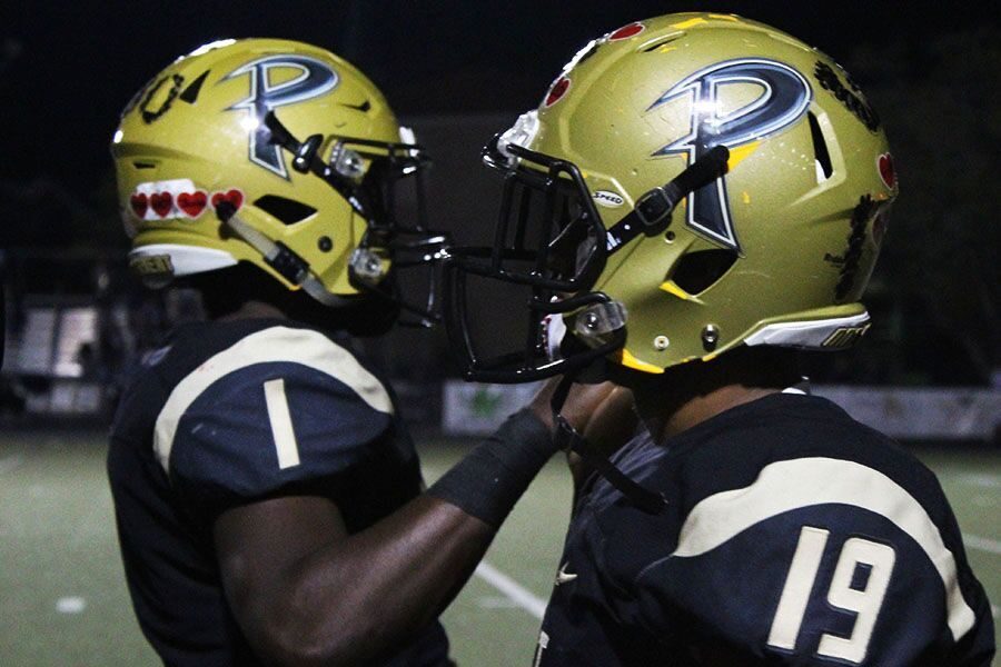 In passing, seniors Derrick Powell Jr. And OJ Augustin pat each other on the back for the last play on Sept. 28. This was the teams second game of the year, winning 36-0 against Sickles.