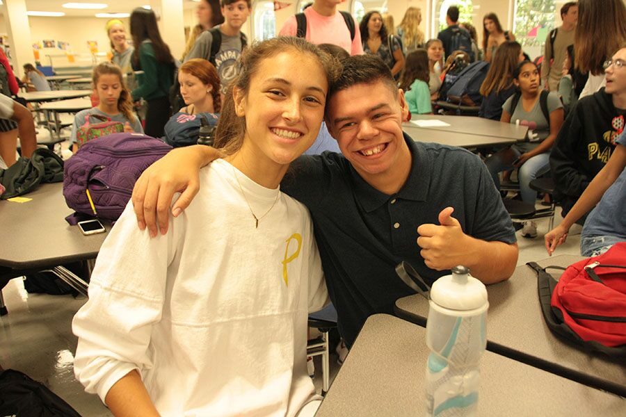 With an arm around sophomore Kendal Cheesman’s shoulder, senior Dylan Mirasola participates in the Best Buddies club meeting. In the cafeteria, Best Buddies sponsor Caroline Medina explained events for the upcoming year. 