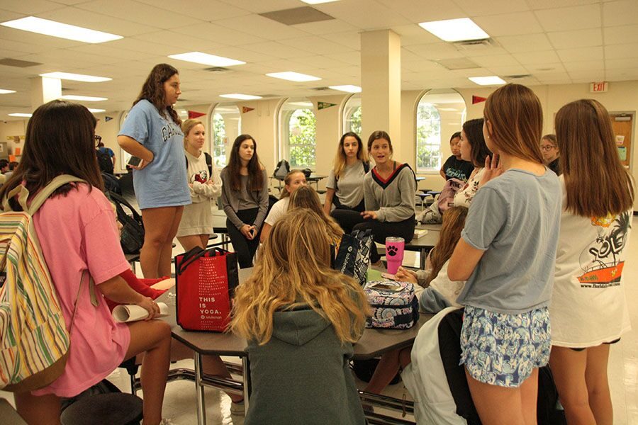 La Sertoa members gather around while senior Cailey Clark explains events that the La Sertoa girls can expect this year. They were informed of upcoming service projects such as the Great American Cleanup and volunteering at Hyde Park. 