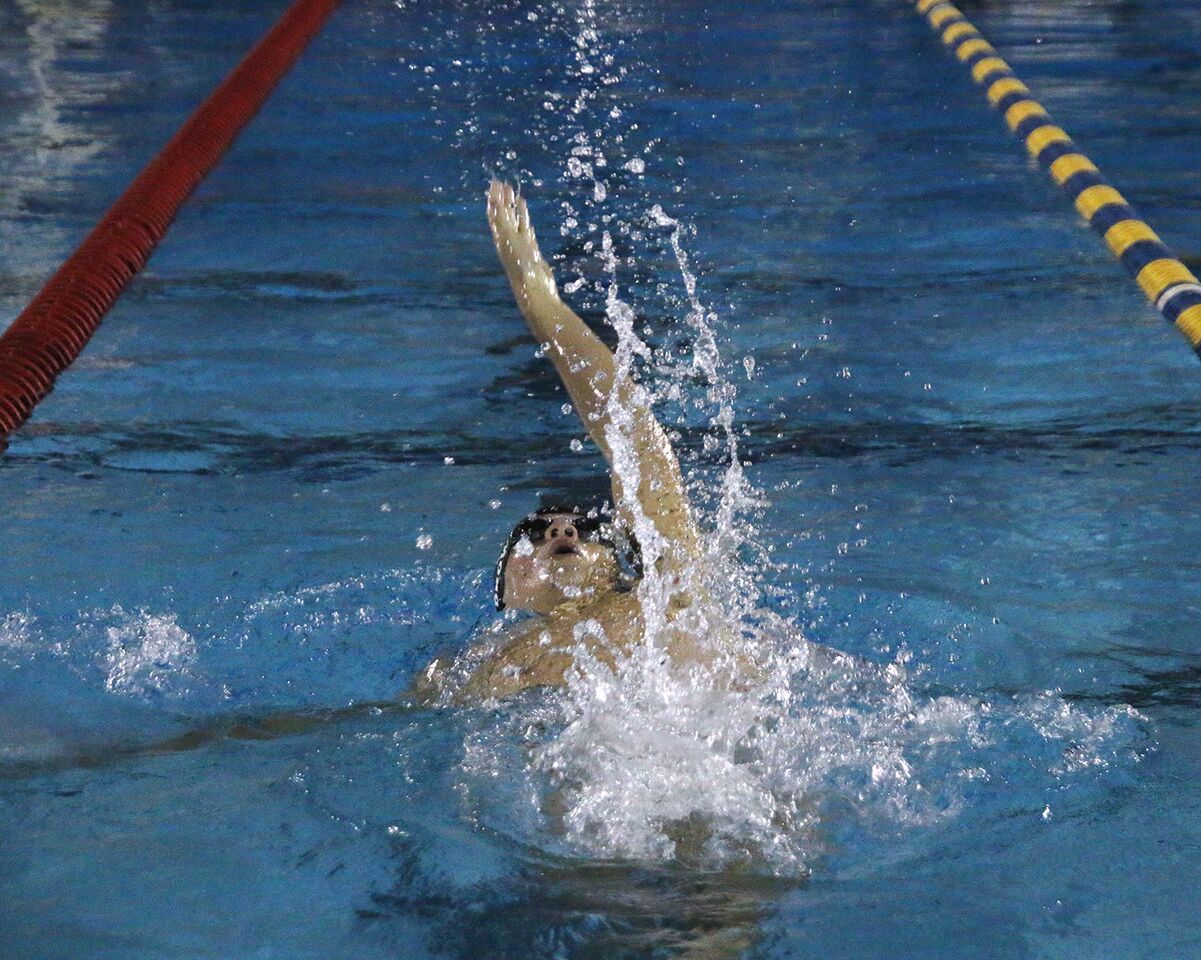 Swimming backstroke, junior Joel Brown swims the boys 200-yard medley relay at Bobby Hicks Pool Oct. 11. Brown placed second in his heat with his team against Wharton High School.