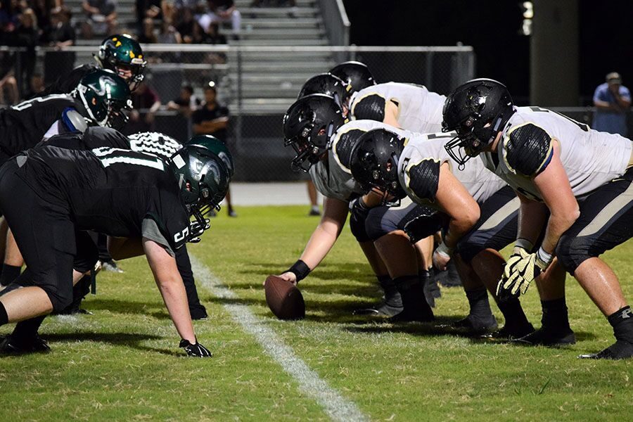 Getting into formation on the line of scrimmage, the offensive line waits for senior center Max Phillips to snap the ball at Sickles High School. The varsity football team gained another win 21-0.  