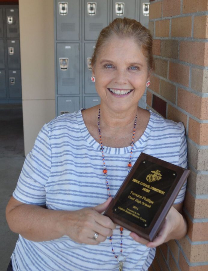 Rewarded by the United States Marine Corp, social studies teacher Tamara Phillips poses with her Honor, Courage, Commitment Award. Phillips received her award during a season football game in 2011, after having survived bone cancer that resulted in surgery and a permanent disability.