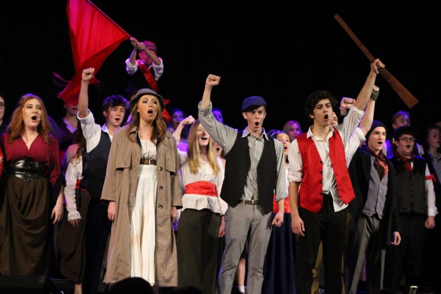 In allegiance for the impending revolution, Varsity Chorale members raise their hands at the end of “One Day More” from the musical “Les Misérables.” Senior Laz Vasquez played the revolutionary leader Enjolras and said his favorite part was “definitely the acting”.  