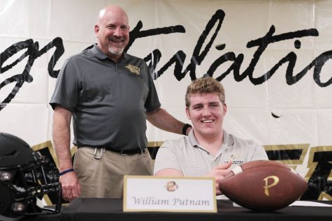 Calling him a “once in a lifetime player,” head coach Robert Weiner introduces senior offensive lineman William Putnam Dec. 20 in the field house. Putnam announced he had signed with Clemson University by pulling out a Clemson hat and placing it on his head. 