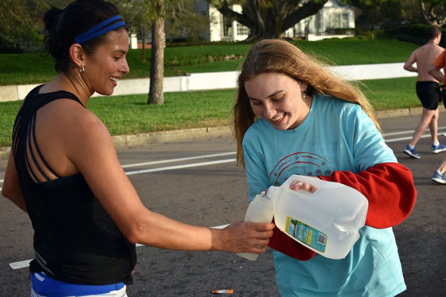 While cheering on runners, junior Olivia Roberts fills up a water bottle in the 8K race Feb. 24 on Bayshore Boulevard. Multiple teams volunteered to raise money Feb. 23-24. 