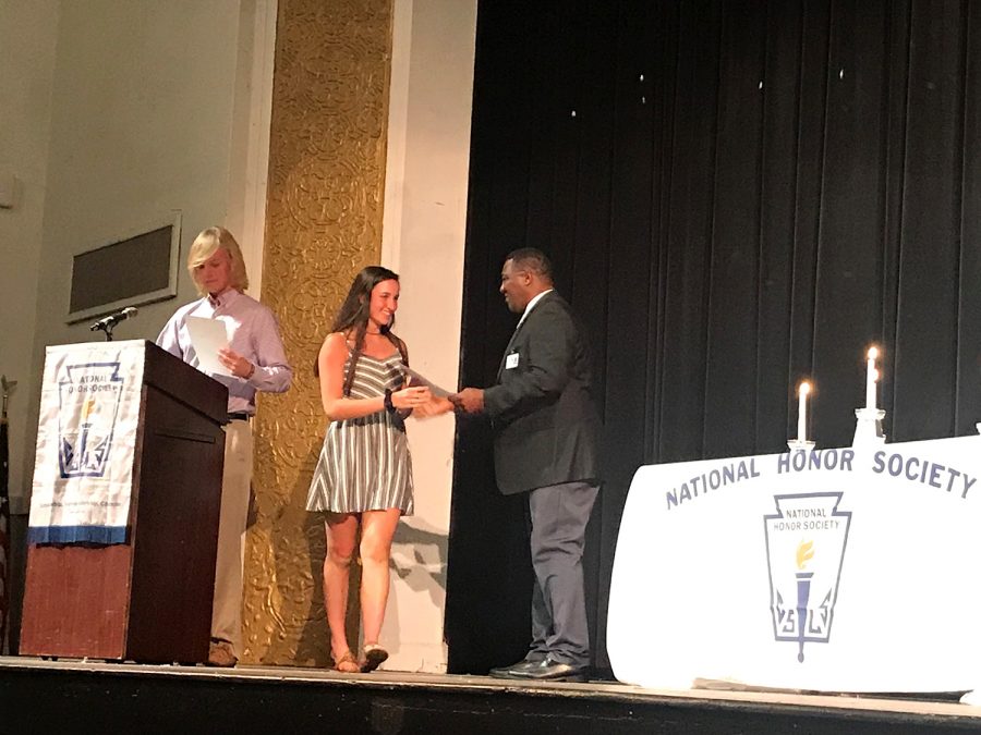 Receiving her certification, new National Honor Society member sophomore Carolee Jones walks across the stage, shaking principal Johnny Bushs hand Tuesday April 9 in the auditorium. The National Honor Society was created in 1921.