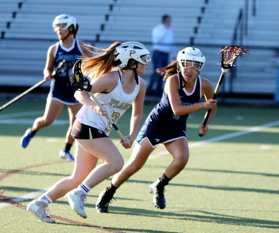 Running with the ball, sophomore Emily Turton heads downfield April 2 at Dad’s Stadium. Turton joined the girls lacrosse team her freshman year. 