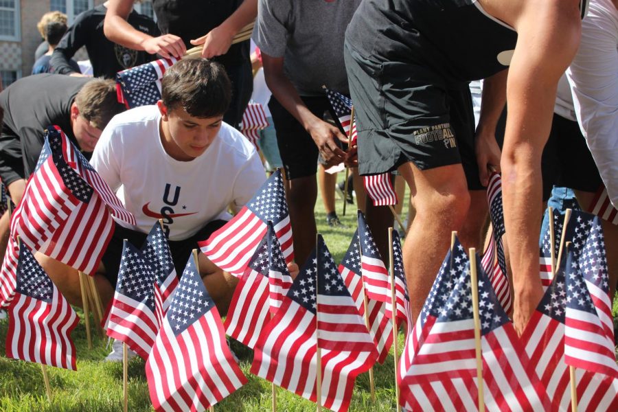 Members of the football team place flags in honor of the 9/11 victims Tuesday Sept. 10. Around 2,977 were killed at the World trade Center towers during the terrorist attack, not including those from the Pentagon. 