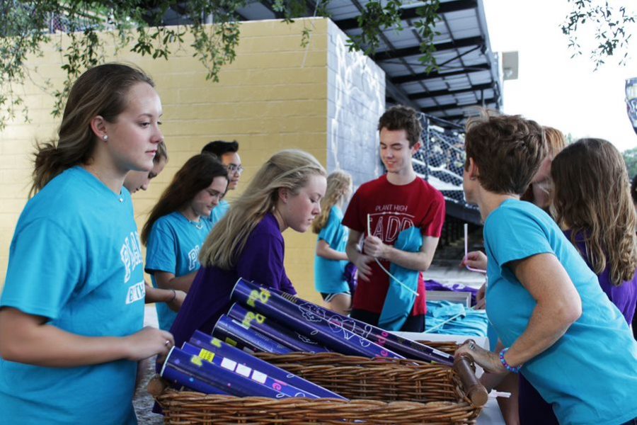 Setting up the table, seniors Lucy Morris and Michael Munkwitz prepare for the Be the Light event, Sept. 20 at Dad’s Stadium. The setup began at 6 p.m. and activities lasted throughout the football game.