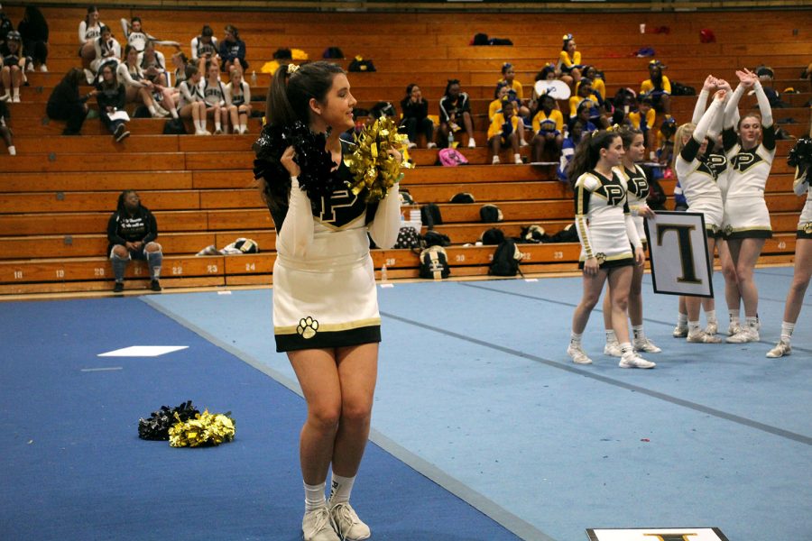 Pom-poms in hand, freshman Bella Guerra chants with the rest of her team at the cheer competition held in the Robinson gymnasium. The girls competed against other Hillsborough county teams, ranked based on difficulty and execution.  