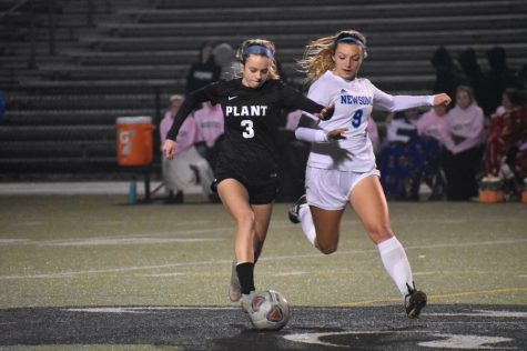Dribbling the ball down the field, junior Victoria Cura tries to escape her opponent. This is Cura’s third year playing forward on the soccer team.
