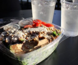Served in a to-go container, the Farmacy’s Herb Roasted Kale Caesar Salad is presented alongside two cups of ice water. The salad was comprised of garlic roasted chickpeas, heirloom tomatoes and avocado atop a mix of kale and Caesar dressing.