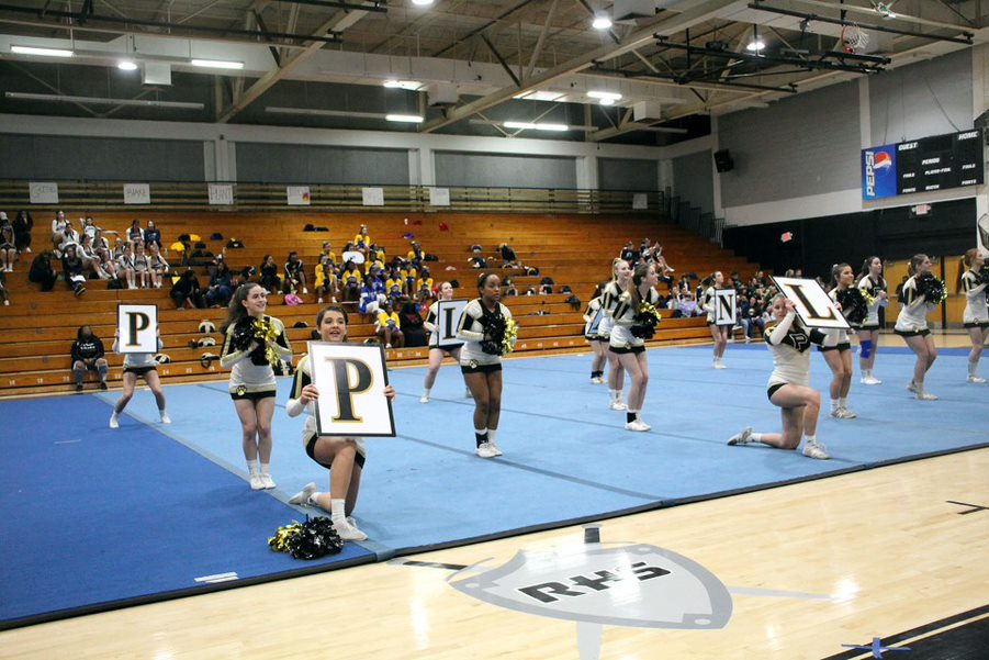 Signs in hands, the varsity team spells out Plant. Sophomore Zoe Hamlin explained that the team’s motivation is to hit their routine, where they make no mistakes throughout the performance.