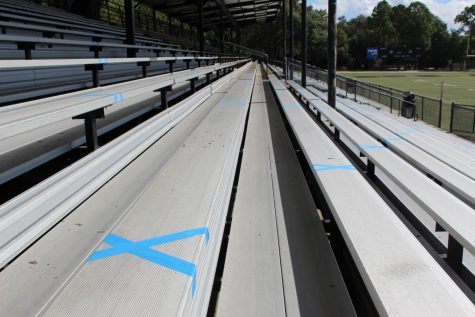 Walking up the bleachers blue masking tape X’s mark where spectators will sit. Each group of four spectators submitted by the student athlete will sit between the X’s.