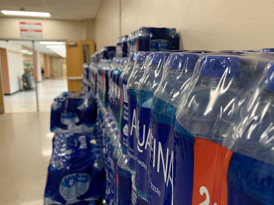 Stacked+three+layers+high%2C+packages+of+plastic+water+bottles+line+the+hallway+near+the+cafeteria.+The+school+began+providing+plastic+water+bottles+this+year+to+compensate+for+water+fountains+being+shut+off+to+prevent+coronavirus+spread.++