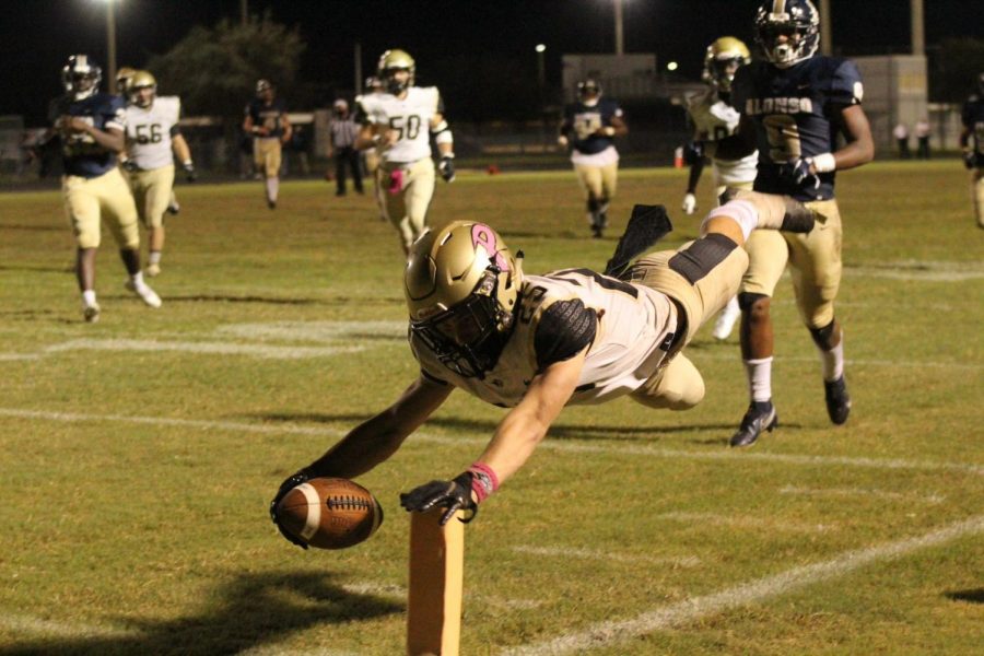 Holding out the ball, junior wide receiver Peter Essad reaches for the end zone. The varsity football team defeated Alonso High School on Friday, Oct. 30 giving them their second win of the season.