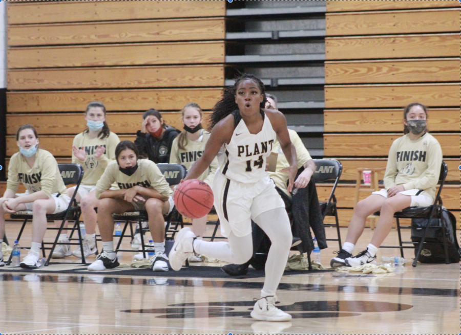 Looking down the court, senior point guard Nyla Jean heads toward the basket. The girls basketball team has started their season with a record of 6-0.