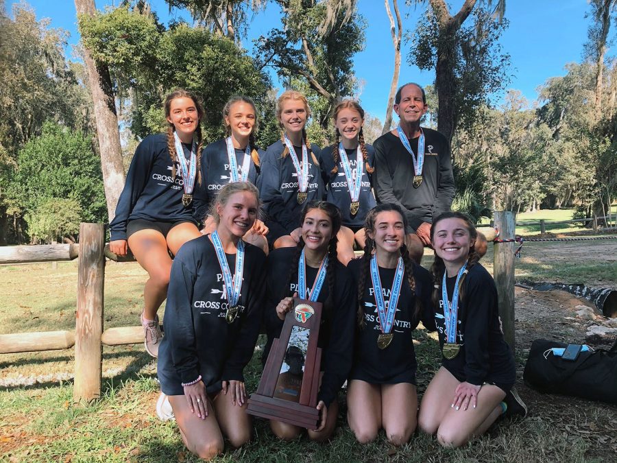Posing with their state championship trophy, the girls cross country team stands together at Apalachee Regional Park in Tallahassee, FL on Nov. 10. They brought home their 12th state title under the coaching of Roy Harrison. 