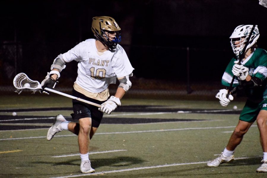 Running with the ball, junior Hayden Stoltzfoos moves toward the goal. Stoltzfoos has played lacrosse for six years and plans to play in college. 