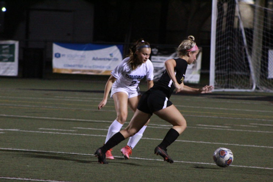 Running, junior Tatum Tishler attempts to further the ball from her opponent. The girls soccer team won their first game against Durant High School 5-4, Nov. 9. 