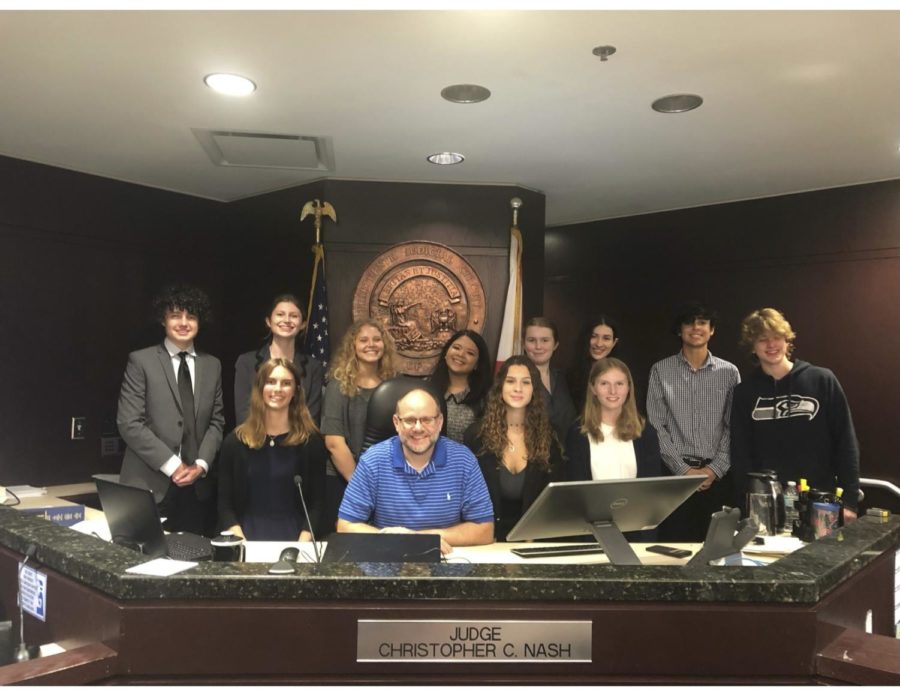 Judge Christopher Nash, with the co-captains- Luke McLaughlin and Kate Bentley, and the rest of the team posing for the camera while in Judge Nash’s courtroom at the George Edgecomb Courthouse. The team participated in the Empire Mock Trial Competition, and placed 13th.