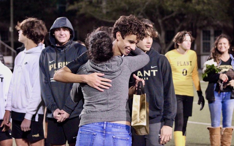 Senior Otis Wildman grins while hugging his coach on senior night. For all the seniors on this team, January 11 was an anticipated day, a day where they celebrated all their accomplishments while being a part of this team.  