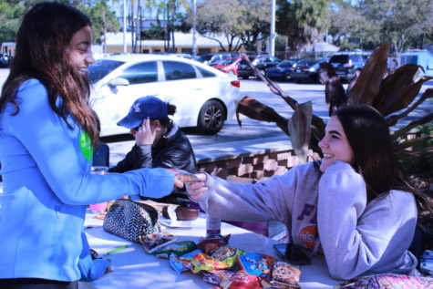 Smiling, senior committee member Silvia Farfante hands a snack to senior Maya Saste before Saste donates blood. Senior committee oversees the quarterly blood drive with OneBlood. 
