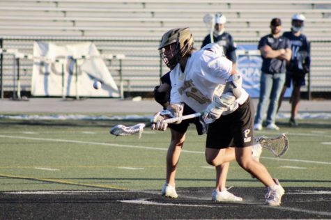 Scooping up the ball, Junior Rogan Kane wins a face off against Wharton. Plant Boys Lacrosse record is 6-1 this season.