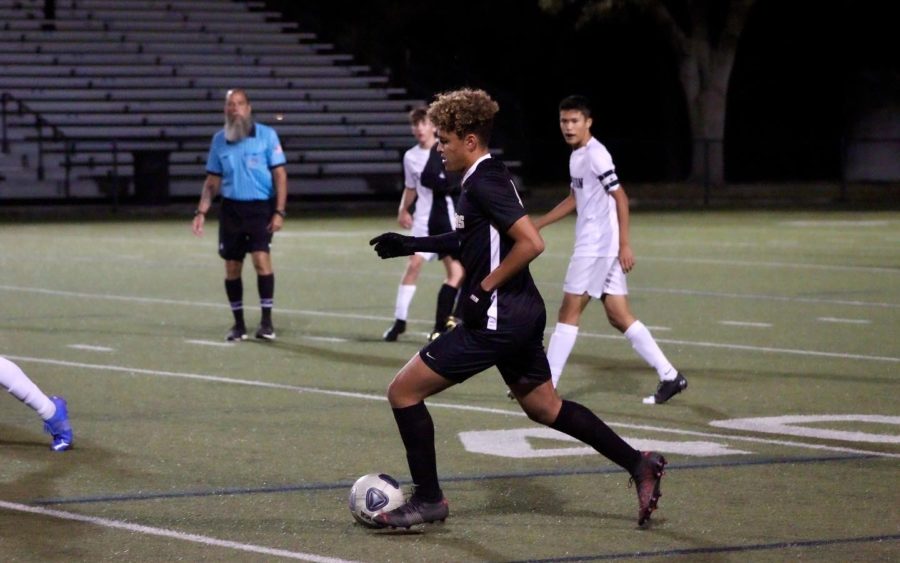 Running with the ball, senior Hunter Jones passes his opponent on the sideline to clear the ball into the offensive zone. Jones has aided with the 4-1 win against Robinson and has won player of the game multiple times throughout this season.  