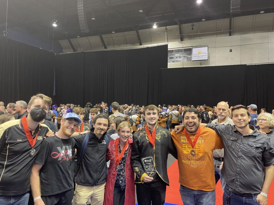 Holding the 2nd place FFCC championship trophy, junior Nate Dibbs is surrounded by the band staff as they celebrate what theyve achieved. Dibbs hopes to win 1st place with his team for his senior year.