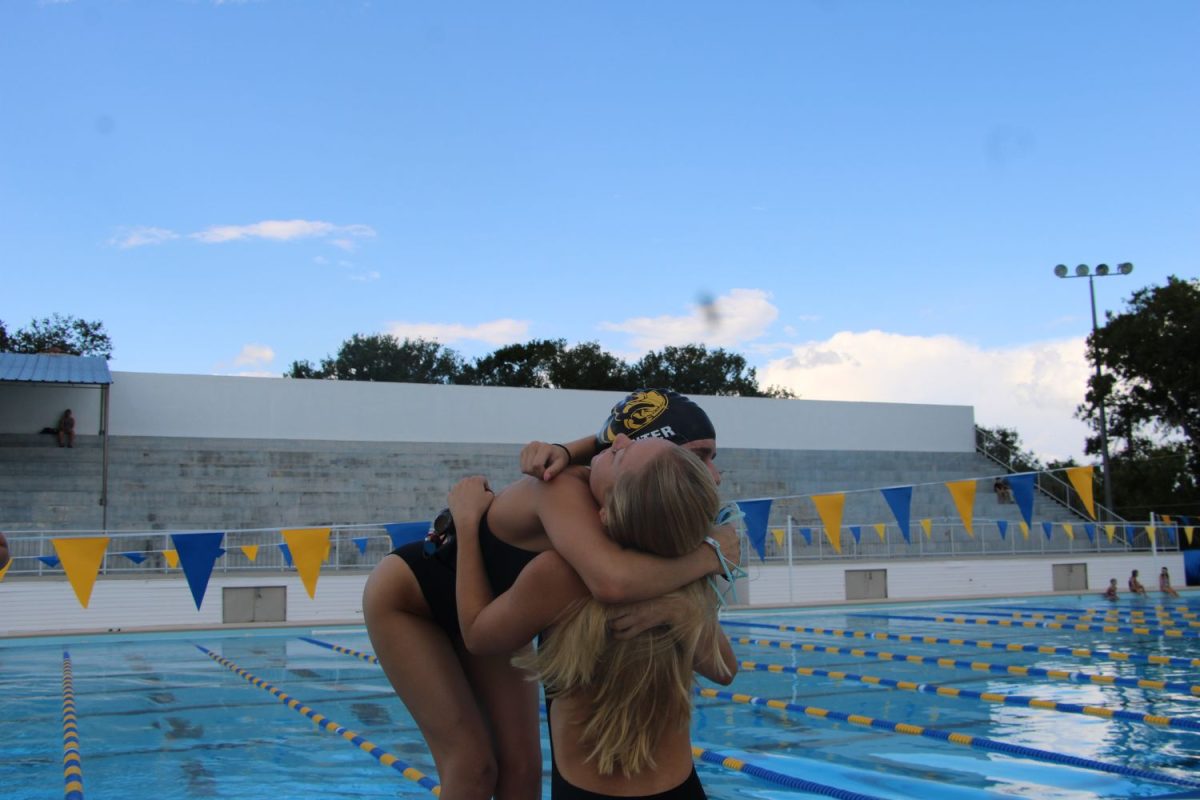 Seniors, Libby Maddux and Abby Pointer hug before one of their last meets on the team. Both Pointer and Maddux have been friends since starting swim and this is their last year together before graduating. 
