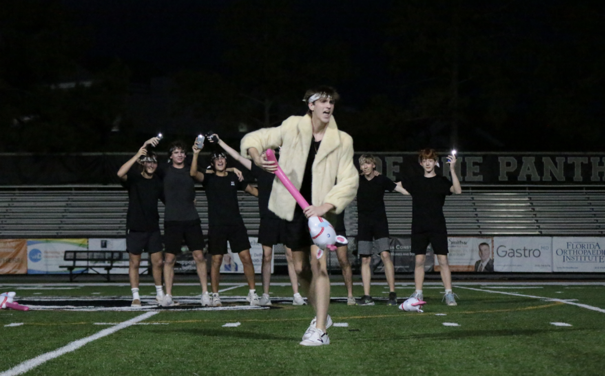 While senior Jackson Gilliam plays the role of Ken from the Barbie movie, La Sertoma boys dramatically light their flashlights during Panther Prowl at Dad’s Stadium Sept. 25.  